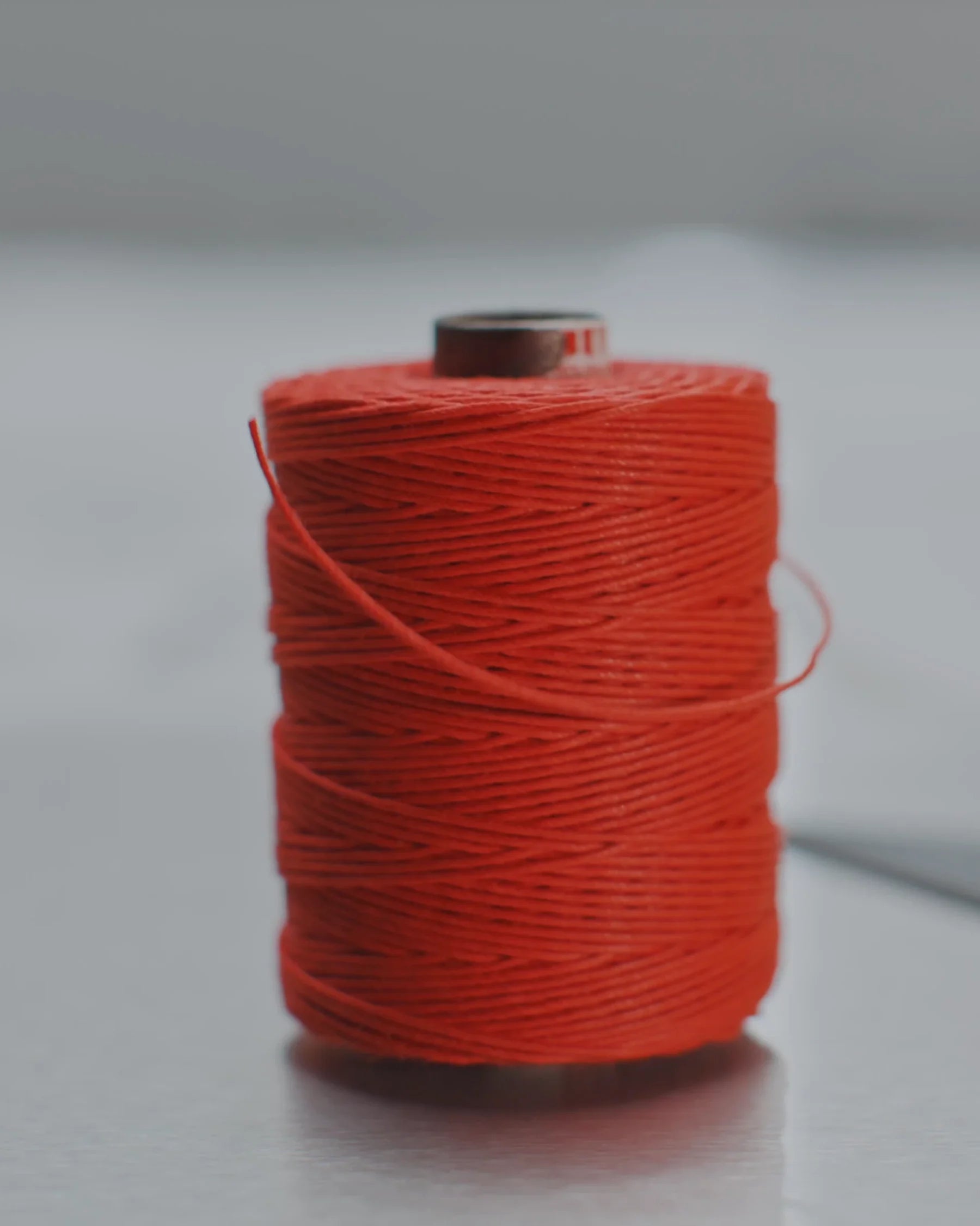Spool of red thread on the cutting table